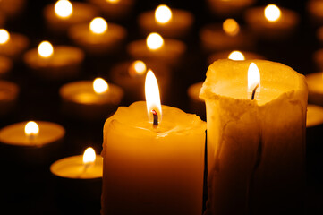 Two burning candles in the dark