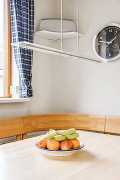 Plate with assorted fruits served on wooden table in kitchen