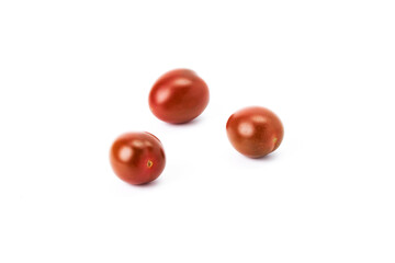 Three red cherry tomatoes on a white background