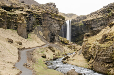 Kvernufoss waterfall, situated in a canyon with a path leading towards it, near Skogar in Iceland