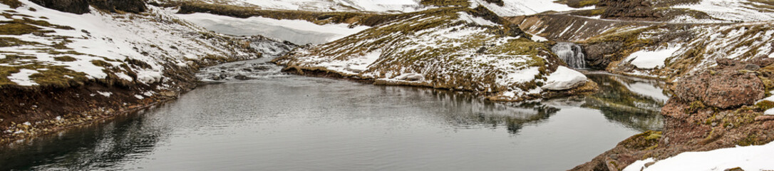 Panoramic view of a double waterfall in the partly snow-covered mountains near Olafsvik, Iceland