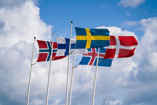 Scandinavian Flags Waving Against Cloudy Sky. Selective Focus.