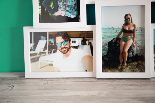 A frame of several photos of a couple in love on their summer vacation, by the beaches of Mallorca. with a gray wooden background and a blue-green fabric.