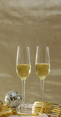 Vertical image of two glasses of champagne, mini disco ball and party glasses