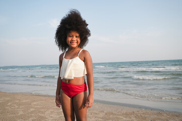 African American kid girl with swim suit on the beach