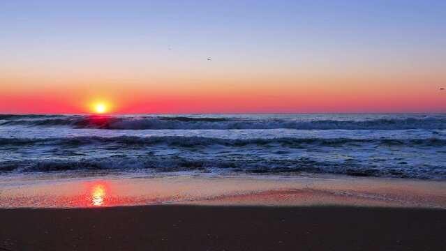 Beautiful sunrise over the sea waves and beach