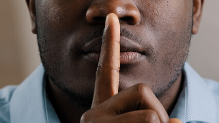 Mysterious unknown male face part african american adult man put finger to lips ask be quiet make gesture silence show secrecy sign keep secret confident information silent forbid tell close up view - obrazy, fototapety, plakaty