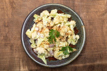 Healthy food cauliflower salad in bowl dish on wood background.