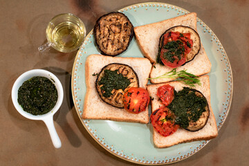 Vegetarian food sandwich with eggplant tomato and olive oil on wood background top view close up.