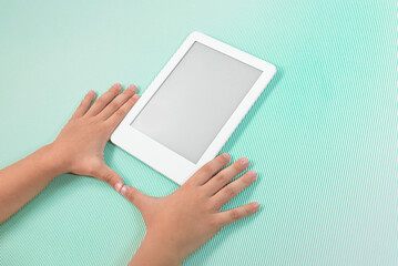 Ebook reader over green background - being held by the hand of a child