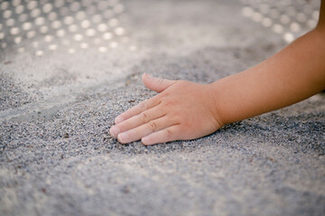 砂遊びする子どもの手