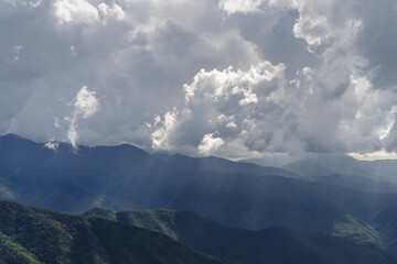 Fototapeta premium Mountains range with stormy sky and sunbeam