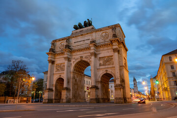 Fototapeta na wymiar Victory gate Siegestor in Munich Germany with traffic lights in the evening