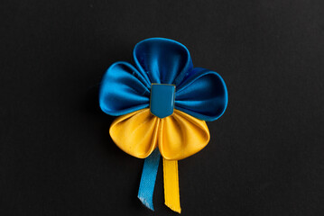 Ukrainian flag flower from ribbons on a black matte background