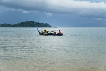 Fototapeta premium Local Asian fisherman boat on the sea with low floating clouds.