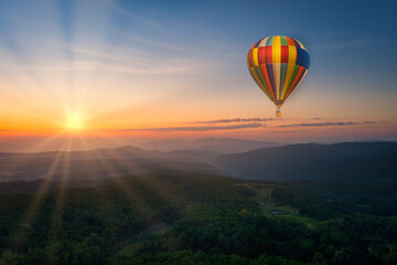 Fototapeta na wymiar Aerial view of sunrise with ballon over mountian and pine tree in Chiang Mai Province, Thailand