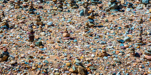 stones laid in a pyramid on the river bank near the forest