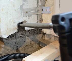 Making a square hole in a concrete wall using a punch tool and a chisel attachment
