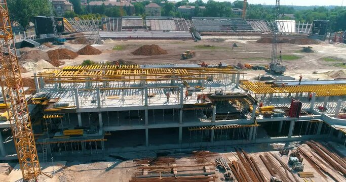 Construction process of a modern football stadium. Builders make formwork at the construction site of a new stadium. Aerial view of reinforced concrete construction