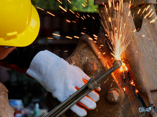 Worker cutting steel with a gas torch. Man cutting steel with propane and oxygen. Processes that...