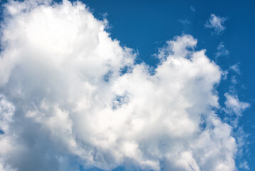 Fluffy white clouds on background of blue sky.