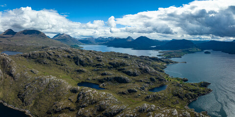 Fototapeta na wymiar Aerial view of the landscape surrounding Diabaig, Lower Diabaig and Torridon village in the north west highlands of Scotland during summer on a blue sky day with light clouds
