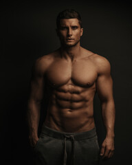 Fototapeta na wymiar Shirtless sexy muscled male model standing in studio