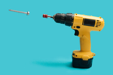 Brushless Cordless Combi Drill that comes from corner and screw that levitate in the air on blue color background © DPA