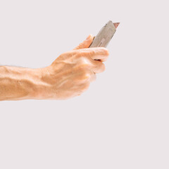 Man hand holds scalpel a tool that’s been utilized by builders to cut. Gray background.