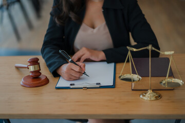 Legal Counsel Concept Lawyer working on office documents with legal tiger skins and injustice goddess scales hammer on the table.