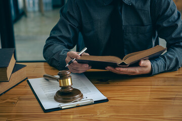 Legal Counsel Concept Lawyer working on office documents with legal tiger skins and injustice goddess scales hammer on the table.