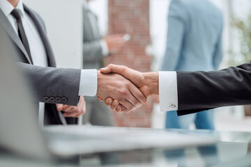 happy business people shaking hands in the office.
