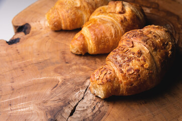 Close-up three a delicious croissant with almonds on a wooden pallet. Delicious and healthy breakfast