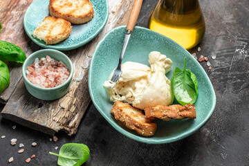 fresh handmade soft Italian cheese from Puglia, white balls of burrata or burratina cheese Basil and Olive Oil and Ciabatta. place for text, top view