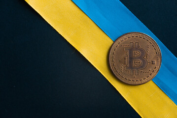 Bitcoin on a black background with the Ukrainian ensign. Concept