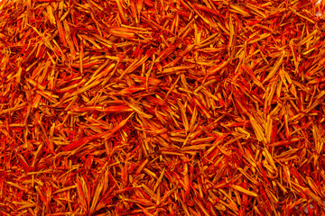 Saffron spice, pistils and stigmas of a crocus flower close-up, flat lay as a background. Indian...