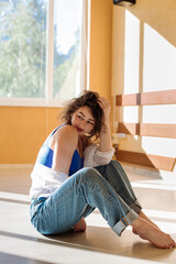 Dancer young girl in casual clothes dancing contemporary dance indoors the hall in morning sun lights