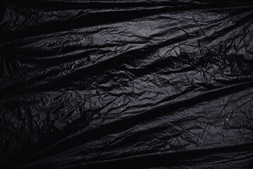 a transparent stretch plastic wrap on black background. realistic plastic wrap texture for overlay and effect. wrinkled plastic pattern for creative and decorative design.
