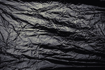a transparent stretch plastic wrap on black background. realistic plastic wrap texture for overlay and effect. wrinkled plastic pattern for creative and decorative design.