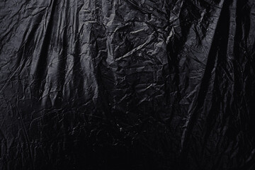 a transparent stretch plastic wrap on black background. realistic plastic wrap texture for overlay and effect. wrinkled plastic pattern for creative and decorative design.