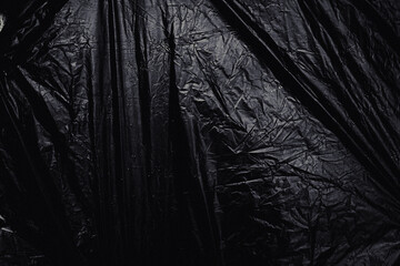 a transparent stretch plastic wrap on black background. realistic plastic wrap texture for overlay and effect. wrinkled plastic pattern for creative and decorative design.
