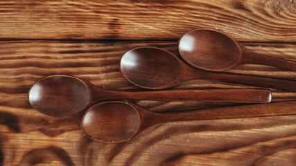 Wooden spoons from dark wood on a wooden table background