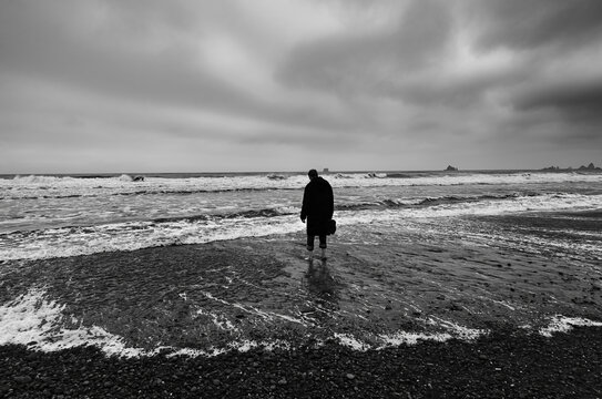 A lonely figure contemplates a gloomy stormy Sea 