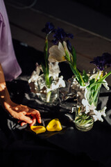 abstraction, flowers tulips, glass vase, girl's hands, on a dark background, rays of sunlight