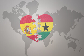 puzzle heart with the national flag of ghana and spain on a world map background. Concept.