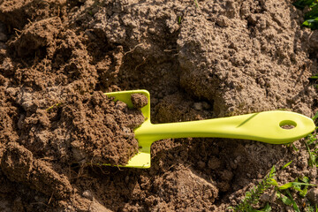 Shovel in the ground. A bed in the garden. Spring, summer time. Cultivation of the land