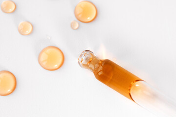 Fototapeta premium Pipette with fluid serum, oil, face gel cleaner. Cosmetics and healthcare concept closeup. Dose of retinol with air bubbles. Flat lay. Monkeypox, coronavirus research