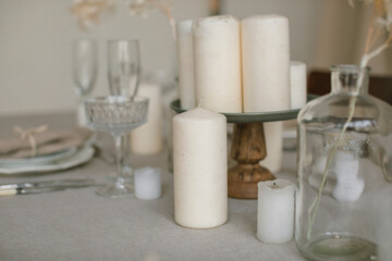 Fototapeta na wymiar Close up of stylish table setting in beige colors. Natural materials, home decorations. Aesthetics.