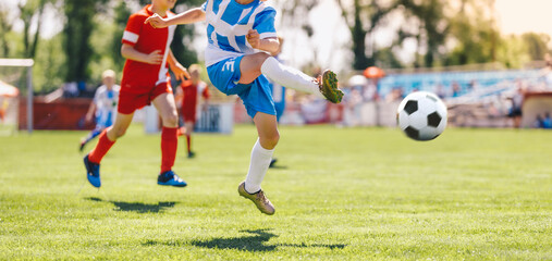 Boy Kick Soccer Ball Towards Goal and Try to Score a Goal. Kids Playing Football Ball on Grass Field. Happy School Boys Kicking Ball During Tournament Game. Children in Blue and Red Soccer Team
