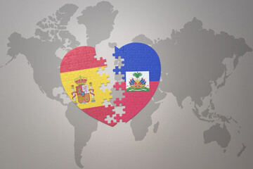 puzzle heart with the national flag of haiti and spain on a world map background. Concept.